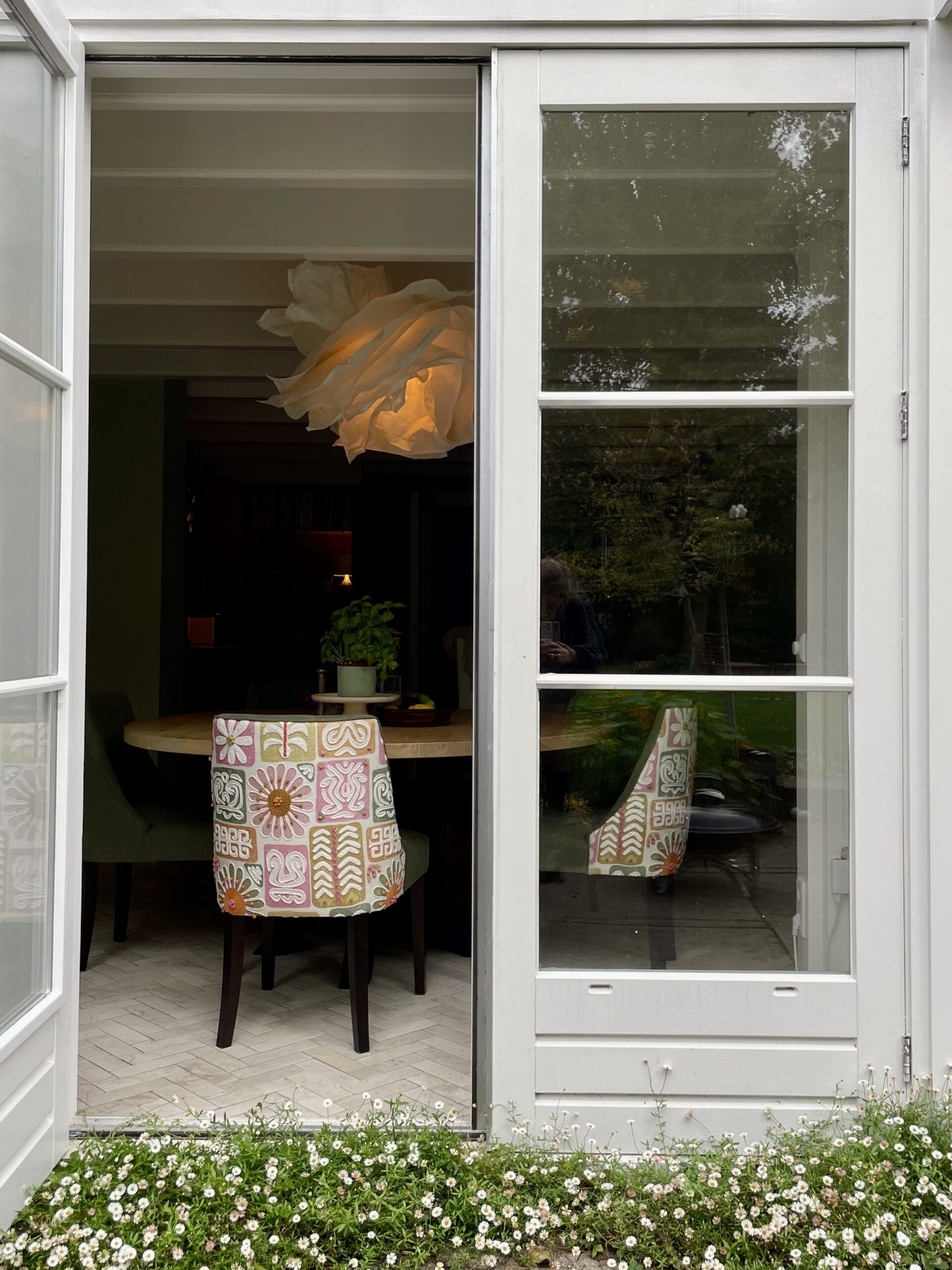 kleurrijk gestoffeerde stoel aan ronde tafel in gezinswoning in Amstelveen
