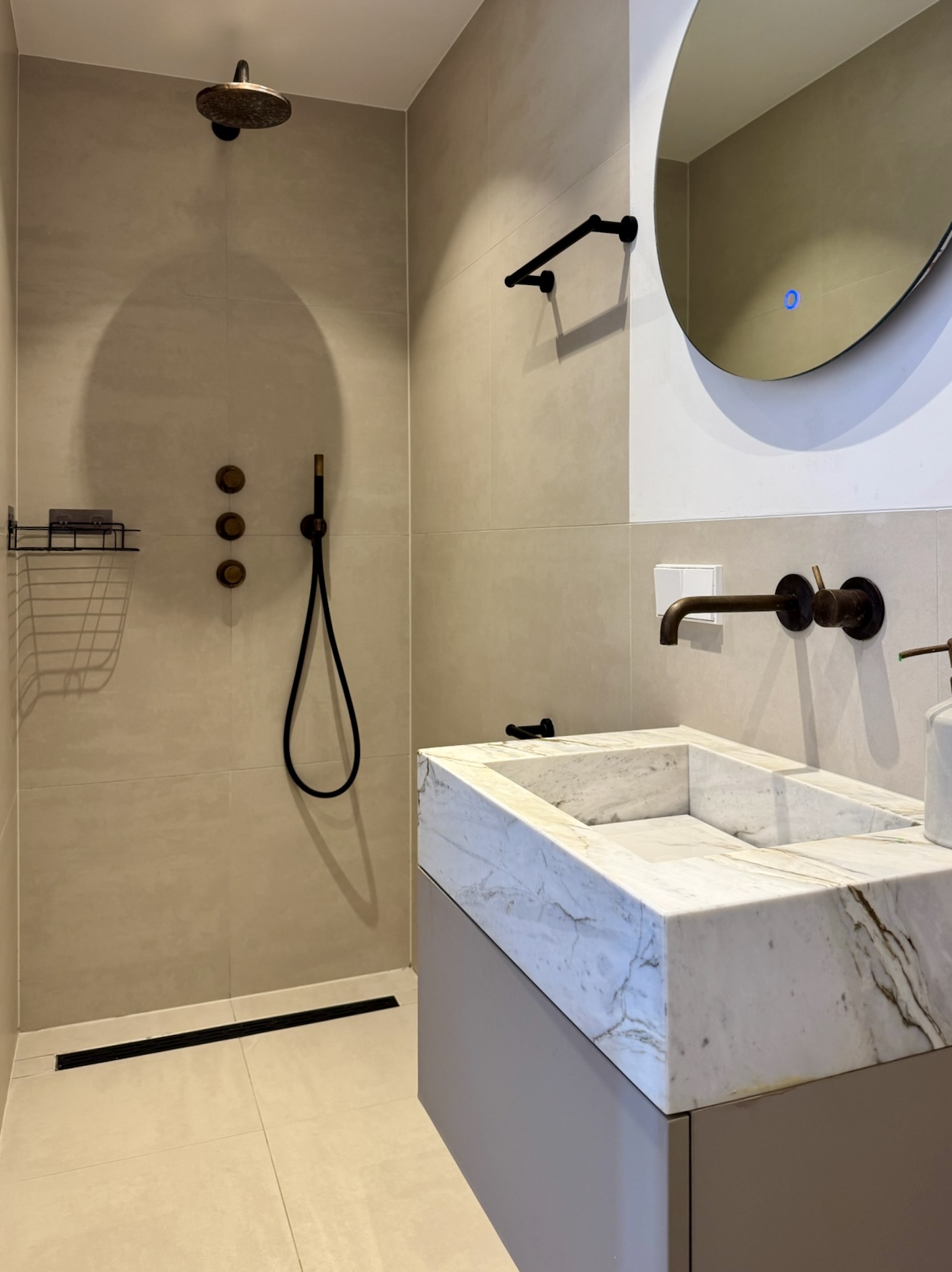 Moderne lichte badkamer met zandkleurige tegels in Laurierstraat Amsterdam interieuradvies